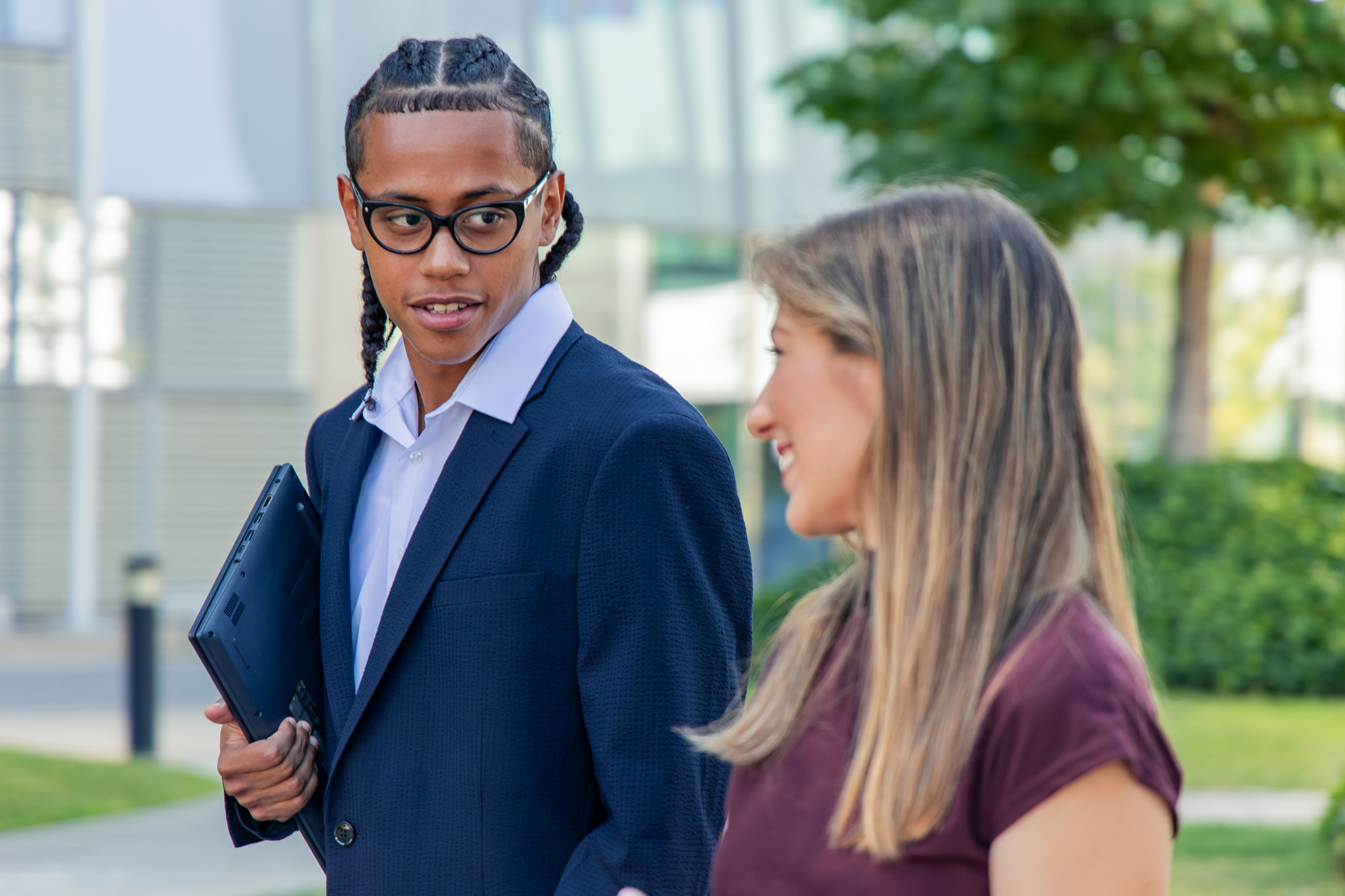 Two lawyers smiling and using an AI tool on their tablet at a wooden table after learning how to achieve AI consistency with IP solutions.